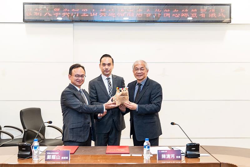 霖雲國際開發總經理張哲明（左起）與阿里山英迪格酒店總經理鄭耀山致贈鄒族文創工藝品予世新大學校長陳清河。（世新大學提供）
