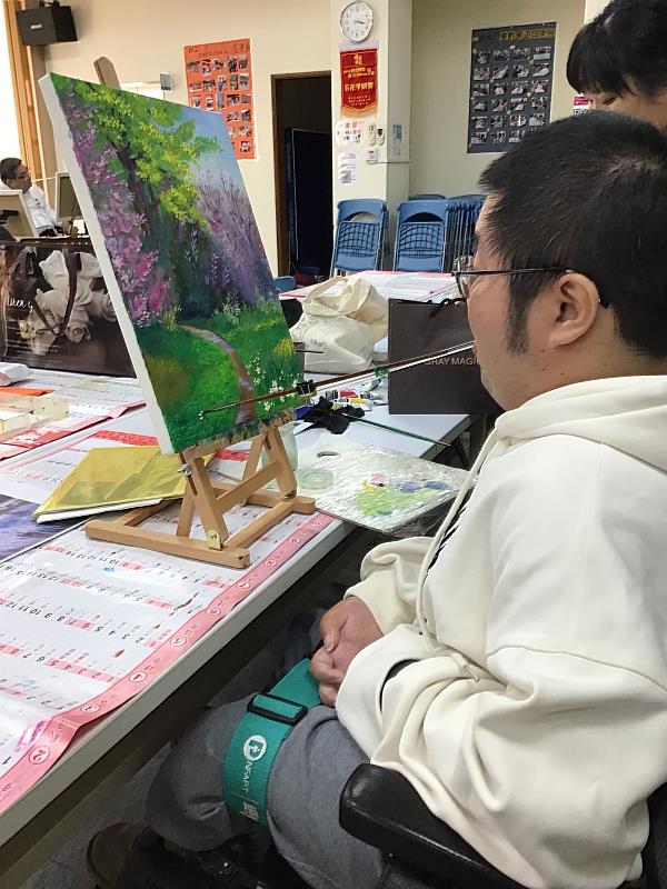 SMA病友沈永德肌肉萎縮只剩下頭部仍能活動，他用牙齒咬著畫筆，一筆一畫描繪出心中嚮往的藍天花海。