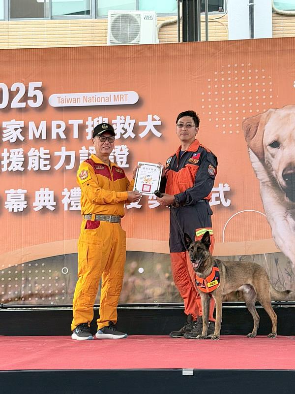 內政部消防署特搜隊隊長陳義豐頒發搜救犬證書。