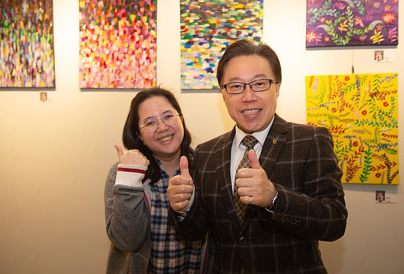 廣告系鈕則勳教授（右）與參展者許惠雯（左）於畫展合影。