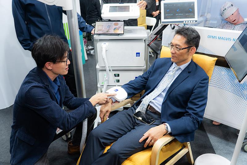 金屬中心劉宗鑫博士(左)為經濟部產業技術司郭肇中司長(右)解說「OPMs光泵腦磁圖診斷與次世代 rTMS經顱磁刺激系統」技術。