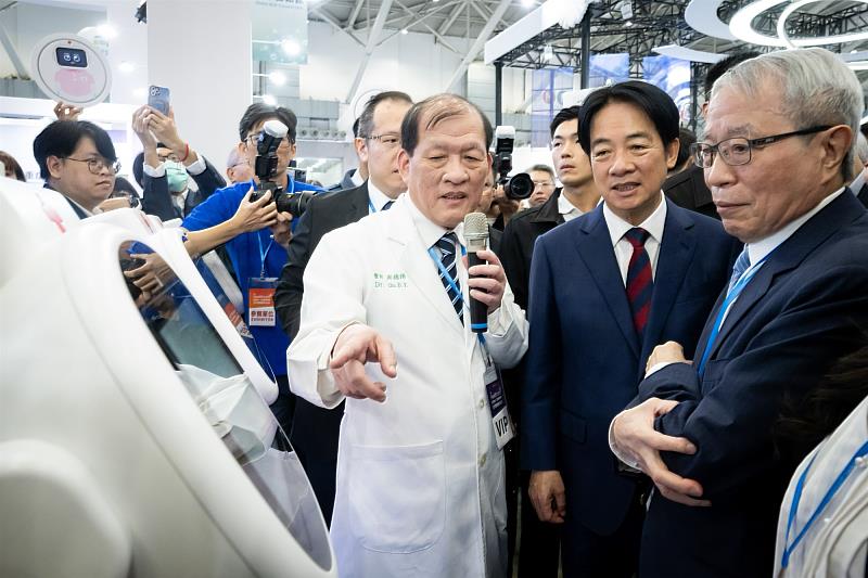 周德陽院長向賴清德總統介紹生成式AI照護型機器人「愛寶EirBot」,右為中醫大院務發展委員會鄭隆賓執行長。