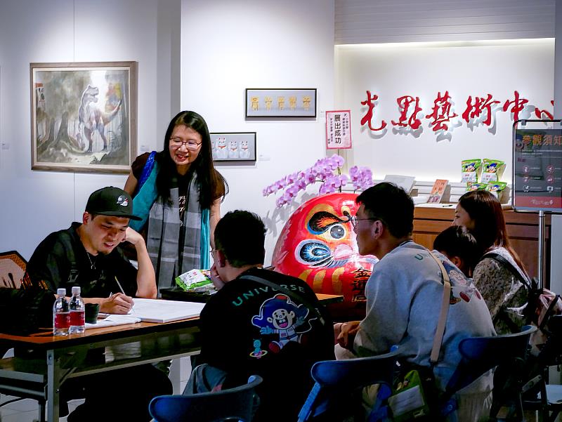 一邊創作、一邊說故事的藝術時光：老師分享乖乖迷信、達摩祈願文化與作畫技巧，像在聽一場結合生活、文化與藝術的小講堂，笑聲與驚呼聲此起彼落。