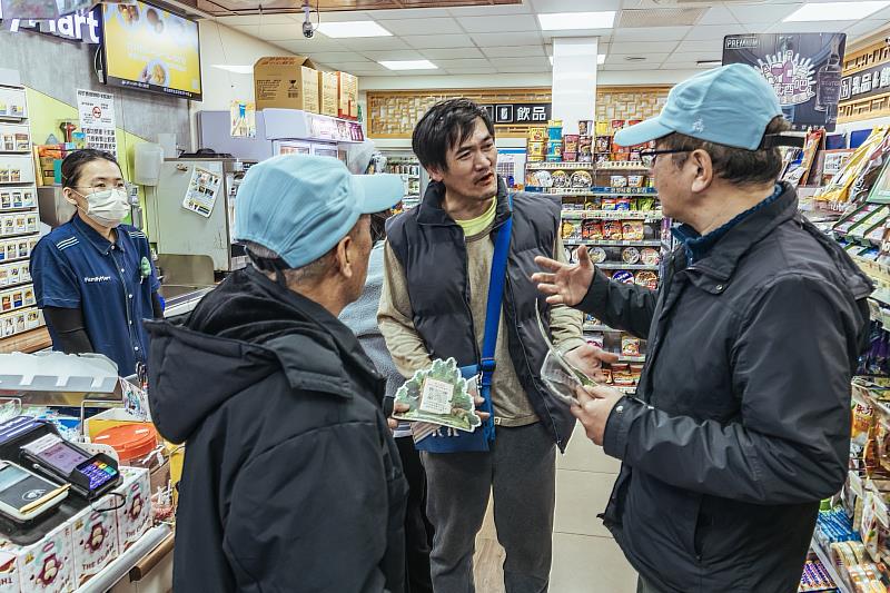 林業保育署臺中分署梨山工作站李彥興主任及梨山里賴聖功里長於全家便利商店和平梨山店與在地居民說明改良式獵具推廣平台的換發方式。