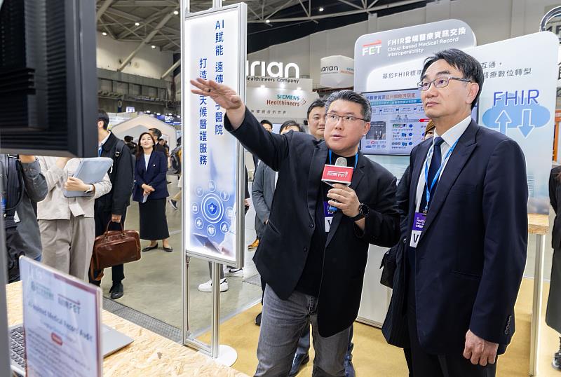 2025台灣醫療科技展，數發部長林宜敬（右）蒞臨遠傳和亞東醫院攤位指導，由遠傳資訊長胡德民（左）接待。