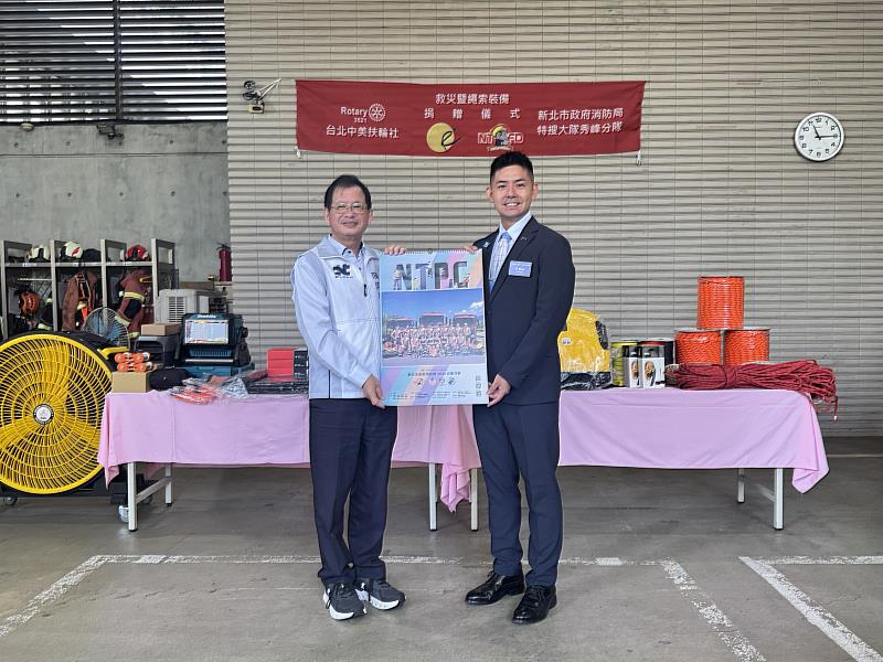 新北消防陳崇岳局長致贈消防月曆給中美扶輪社社長楊貫中（右）。