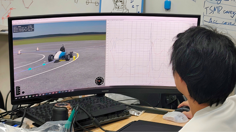 A member of NYCU Vulpes Racing uses engineering simulation tools to analyze vehicle dynamics and performance parameters.