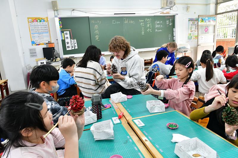 大學伴與小學伴進行松果彩繪創作,大手牽小手畫面暖心又充滿創意。