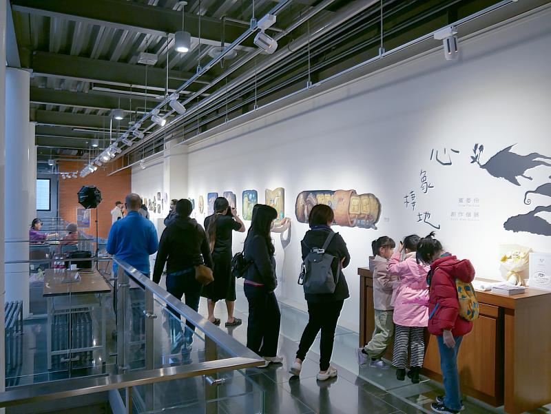 展場一隅，人潮駐足觀展。不少路過民眾被現場創作吸引，停下腳步欣賞展覽作品，展場自然形成交流與聚集的場景。