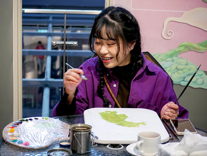 藝術家董晏伶現場創作側拍。董晏伶於鶯歌光點展場中進行即席油畫創作,專注於畫布前,以細膩筆觸讓畫面逐步成形。