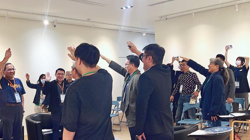 7校USR團隊夥伴站起來，宣示彼此講真話，從舉手、指向、微笑的瞬間，可以看到尬聊大會成功破冰的成果。