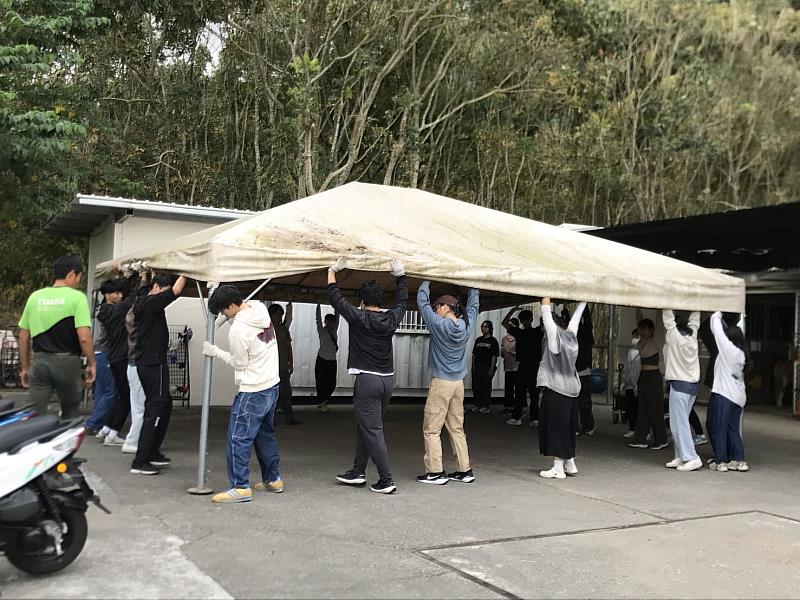 學生發揮螞蟻搬家精神搬運大棚架。