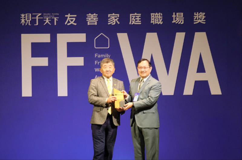 行政院政務委員陳時中（左）頒發「友善家庭職場獎」獎座予玉山人資處處長郭宸巖（右）。