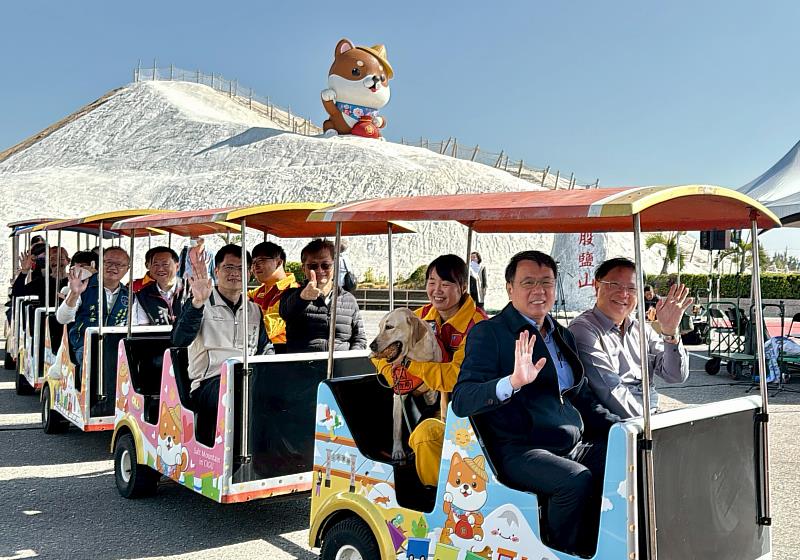 七股鹽山最萌「寵物列車」首航！臺鹽公司董事長丁彥哲（第一排左）與臺鹽公司總經理李杰翰（第三排右）偕同雲嘉南濱海國家風景區管理處處長徐振能（第一排右）、台南市政府觀光旅遊局副局長鄭道立（第三排左）與搜救犬「Stitch」、「Taco」開心搭車遊園，展現「城市英雄」與「鹽山守護犬」的溫馨同框，邀請全台飼主帶毛孩來七股享受兜風樂趣。