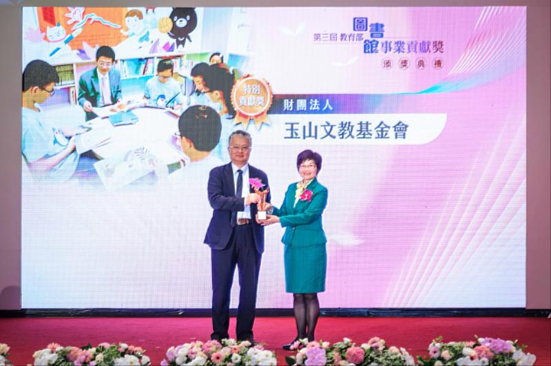 玉山文教基金會榮獲教育部「圖書館事業貢獻獎」，教育部政務次長劉國偉(左)頒發獎座予玉山文教基金會執行長許美麗(右)。