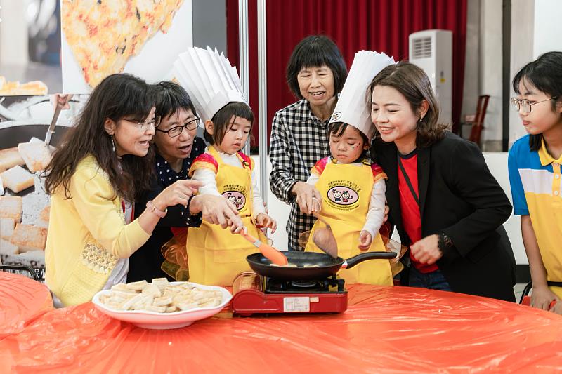 南臺科大青銀共創USR計畫主持人陳美珠老師（左1）與幼兒園高碧君園長（左6）帶領幼兒與長輩體驗「蘿蔔糕共煮」，實踐社區共好。