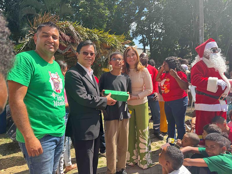 受贈孩童對於獲得聖誕禮物開心展示，現場充滿節慶氣氛。