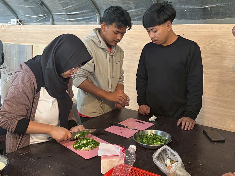 農場廚房手作時間，學生分工切菜準備自煮料理。