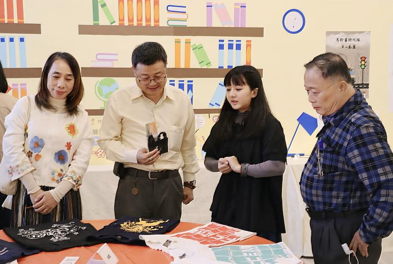 南華大學文創系舉辦畢業展,學生為參觀者介紹展示作品。