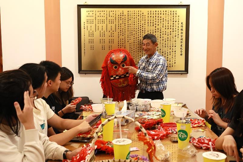 在地職人謝俊煌師傅親自授課，向新加坡與南臺學子解說西港金獅陣文化，並手把手指導獅頭面具製作與彩繪技藝，讓傳統藝術在跨國交流中傳承。