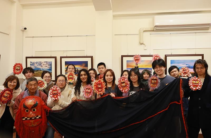 南臺科技大學與新加坡南洋理工學院（NYP）師生合影，展示親手彩繪的金獅面具，體驗西港藝陣文化的獨特魅力。
