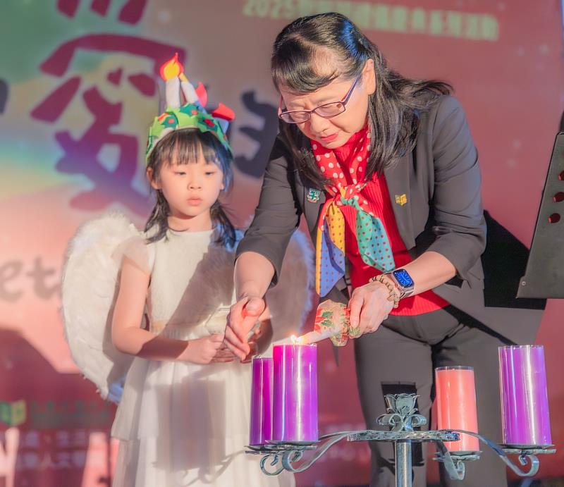 莊慧玲校長(右)從小天使手中傳光，點亮將臨圈第一根蠟燭。
