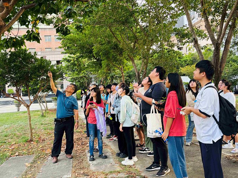 業師黃毅斌帶領學生進行校園植物走讀，並進行解說