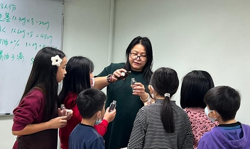 老師示範分裝手工皂原料，孩子們靠近觀察，理解製作流程。