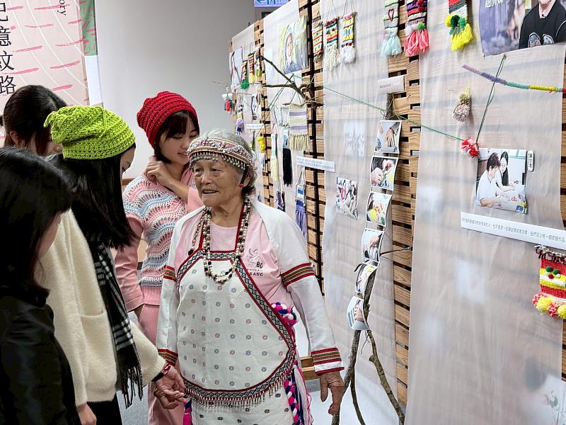 Payi與大學生手牽著手一同欣賞一起做的作品。