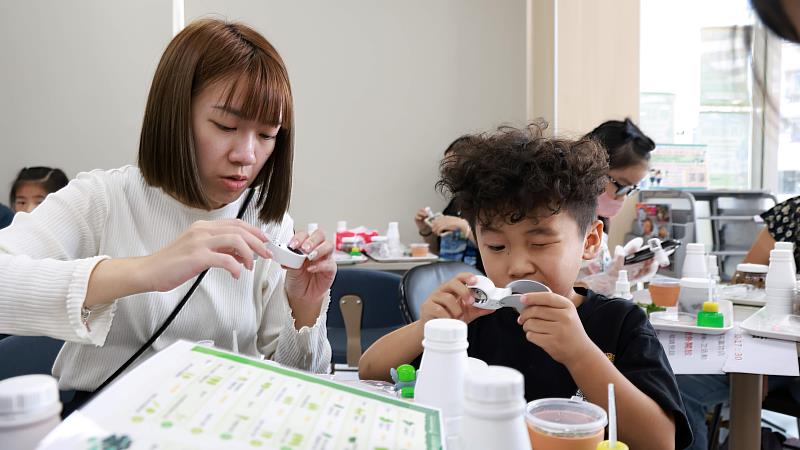 民眾透過放大鏡仔細觀察苔蘚。