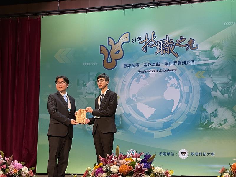 教育部常務次長朱俊彰(左)頒獎給得獎者勤益機械工程系學生鐘興國同學。