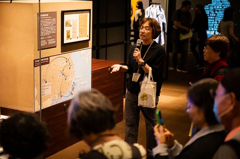 策展人劉維瑛為貴賓導覽解說，在地圖前方生動精采介紹臺灣女性的移動過程。