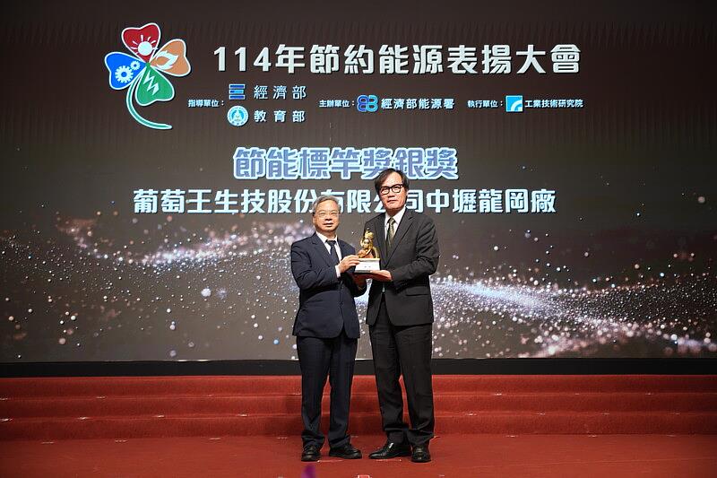 經濟部長龔明鑫（左）頒發獎座予葡萄王生技代表製造處處長胡怡儒（右）。