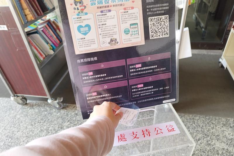 南大學生將發票投入發票箱，以實際行動響應圖書館推動的公益與永續理念。