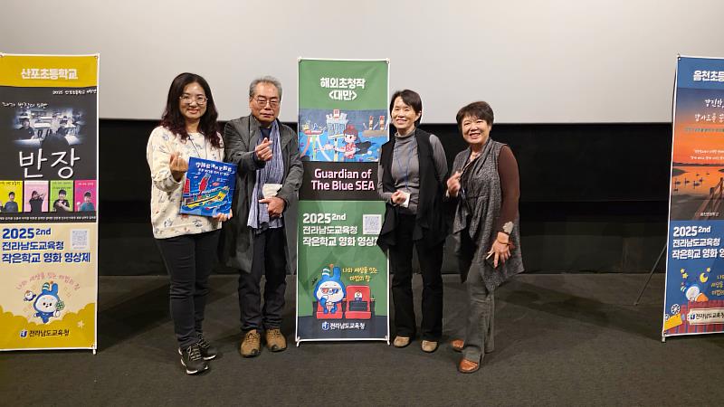 曾惠青副教授（右2）於播映前與作品《守護藍海的王船爺》的海報合影。