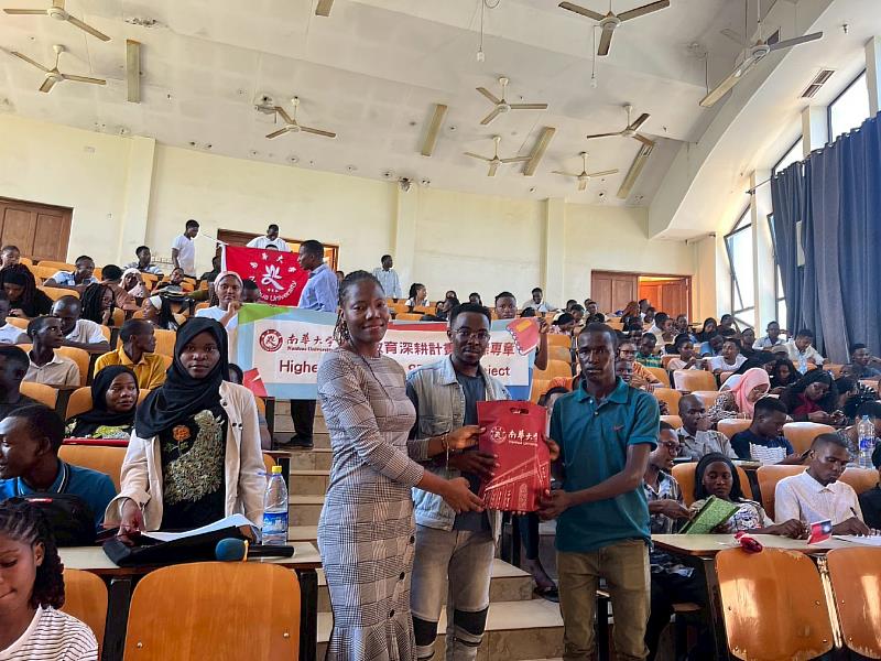 南華大學執行高等教育深耕計畫－國際專章，國際生至坦尚尼亞SUA大學宣導健康衛教、性別平等及公衛疾病預防等知識。左1為馬拉威籍的沐語彤，左2為坦尚尼亞籍的麥可，代表學校致贈紀念品。