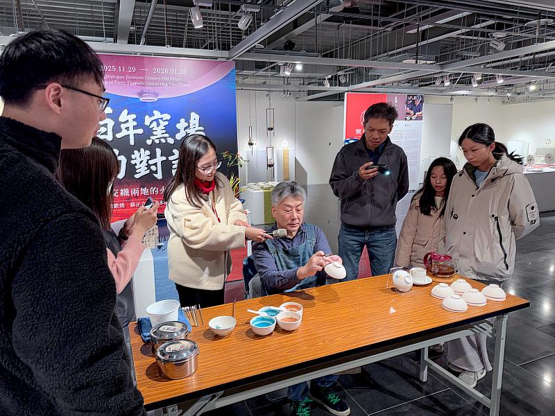 蘇正立老師現場示範釉下彩彩繪,從筆法到色彩層次細細說明,吸引學員們圍繞欣賞,專注聆聽創作秘訣。