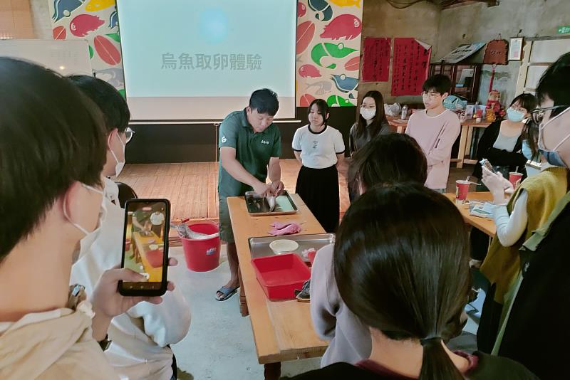 在地青農邱創褘示範烏魚取卵步驟，向南大師生解說養殖與加工的實務細節。