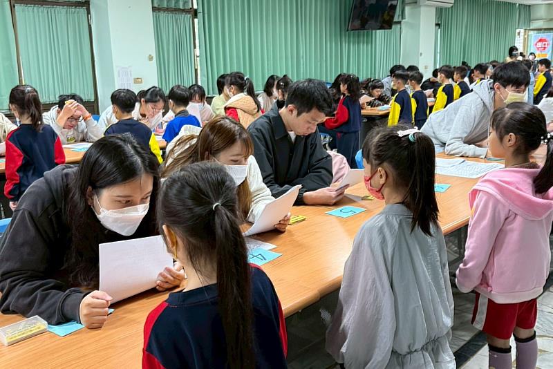 南大師資生於讀經檢測現場引導學童應試，近距離觀察學習表現與教學互動。