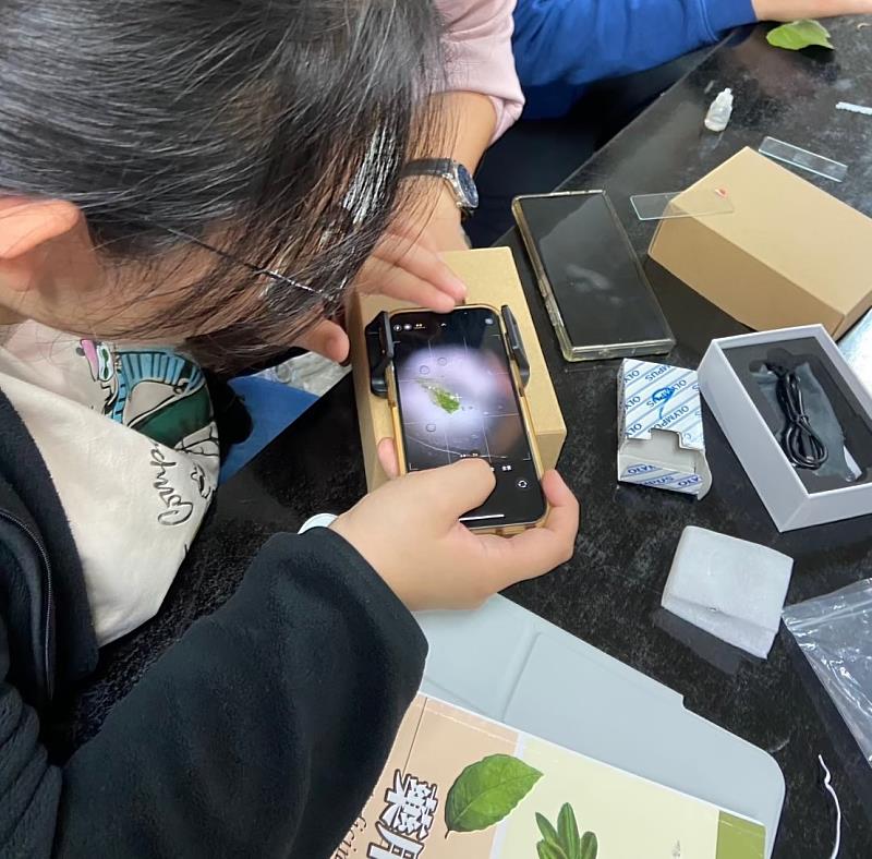 嘉藥藥學系學生用手機顯微鏡細心觀察植物組織構造。