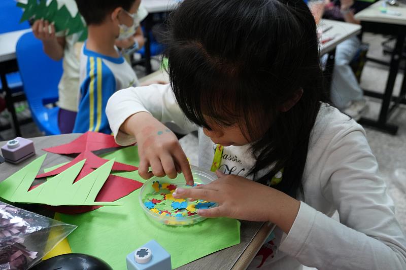南大聯電課輔中心舉辦聖誕感恩親師生合作手創聖誕樹活動，學童尋找適合自己聖誕樹的的裝飾品。