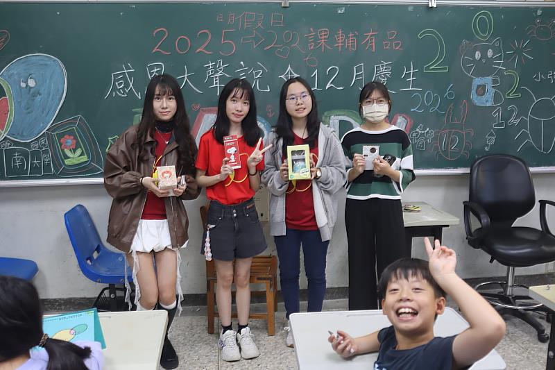 南大聯電課輔中心課輔老師與志工於跨年感恩活動中領取紀念物品合影，展現課輔團隊溫暖陪伴的凝聚力。