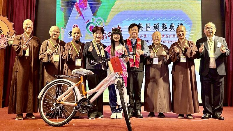 4、嘉義縣政府教育處長李美華致贈腳踏車給入圍全國普仁獎的孩子。（靈鷲山佛教教團提供）