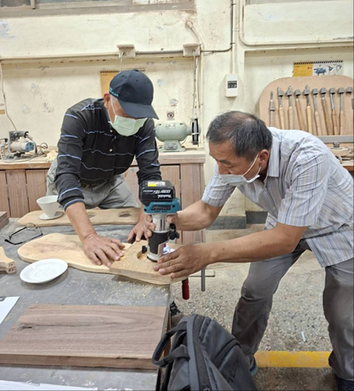 聯大工設系張建成教授協助學員操作鋸木機台。