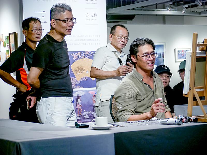 展覽活動創作示範紀錄照:薛宏瑋於展覽限定活動現場示範創作,近距離帶領觀眾看見「雨、光、人物」如何在一瞬間被定格成畫面語言,互動熱絡,也預告他此次回到ONE ART Taipei 2026將帶來更多新作。