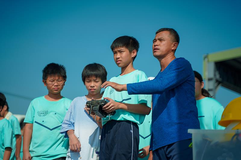 講師協助學童體驗植保機操作。