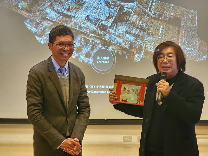點雲科技重現六堆風華，文化部文化資產局文化資產保存研究中心主任陳柏欽（右）致贈代表傳統建築之書籍給客委會客發中心主任何金樑（左）。