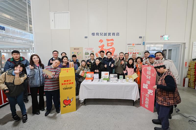 邱副市長與愛恆董事長及慢飛兒們在公益商品前合影。