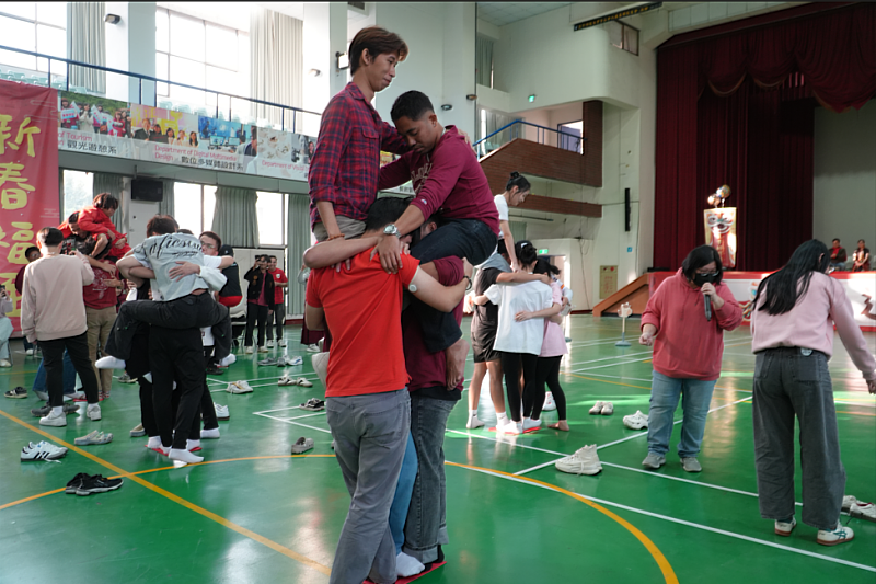 首先登場「馬上抱緊」，考驗同學在逐漸縮小的紙張上維持站立平衡，象徵同舟共濟、緊密團結的合作精神。