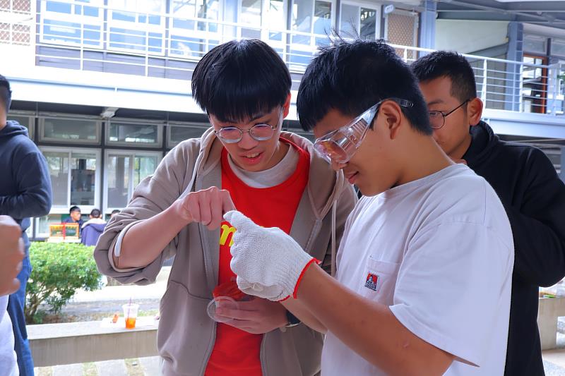 大哥哥陪國中生做「穿針體驗活動」。